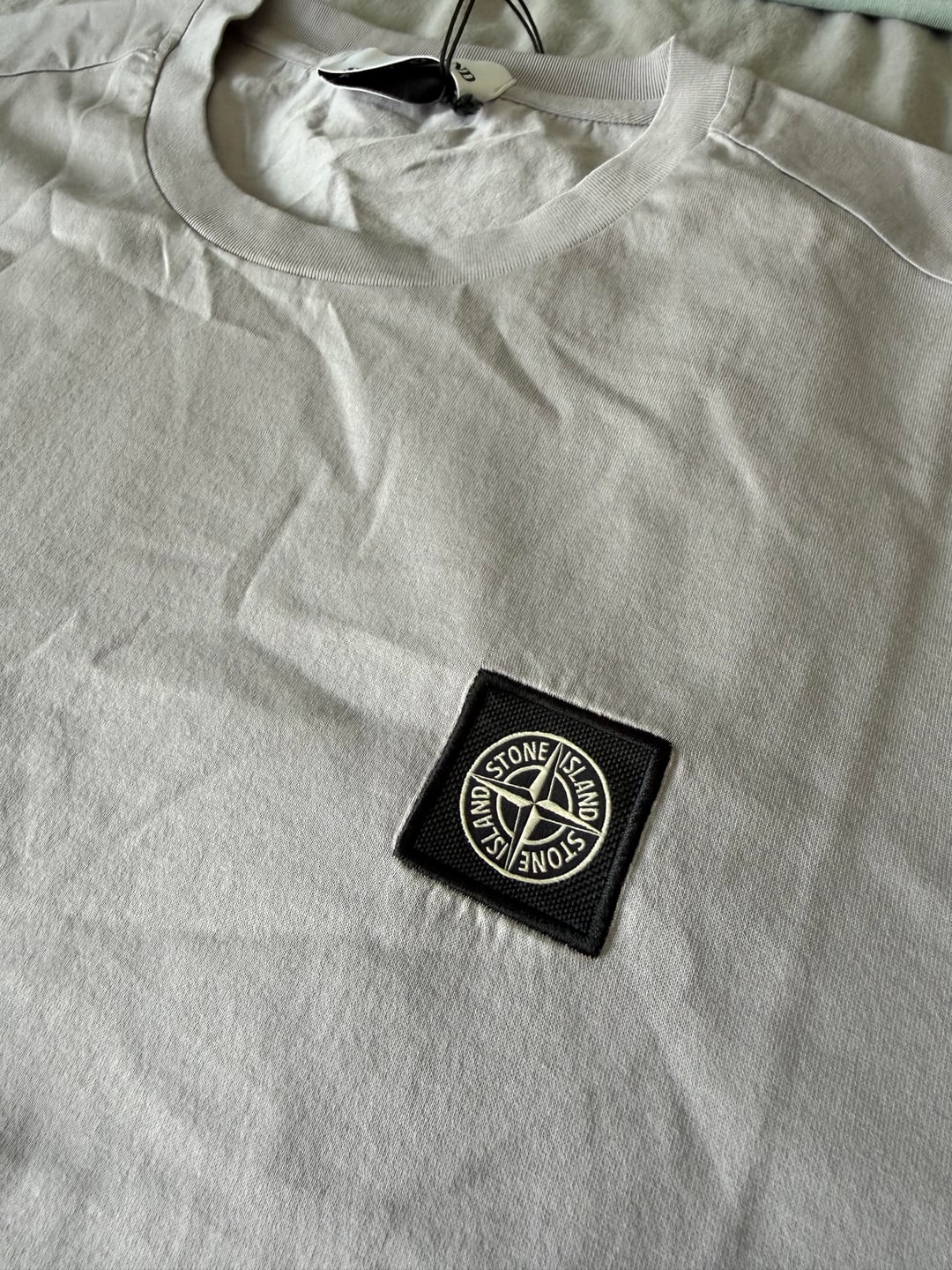 Grey T-shirt badge close-up